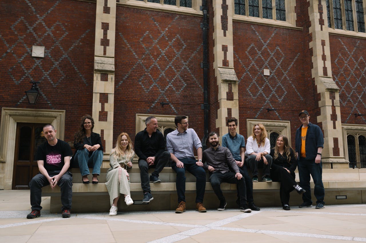 JECO team of 10 people sitting on a bench